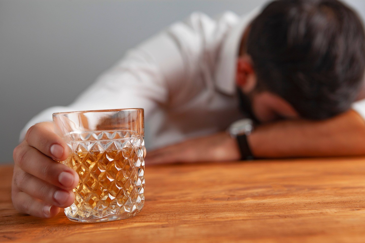 Men drinking a glass of alcohol.
