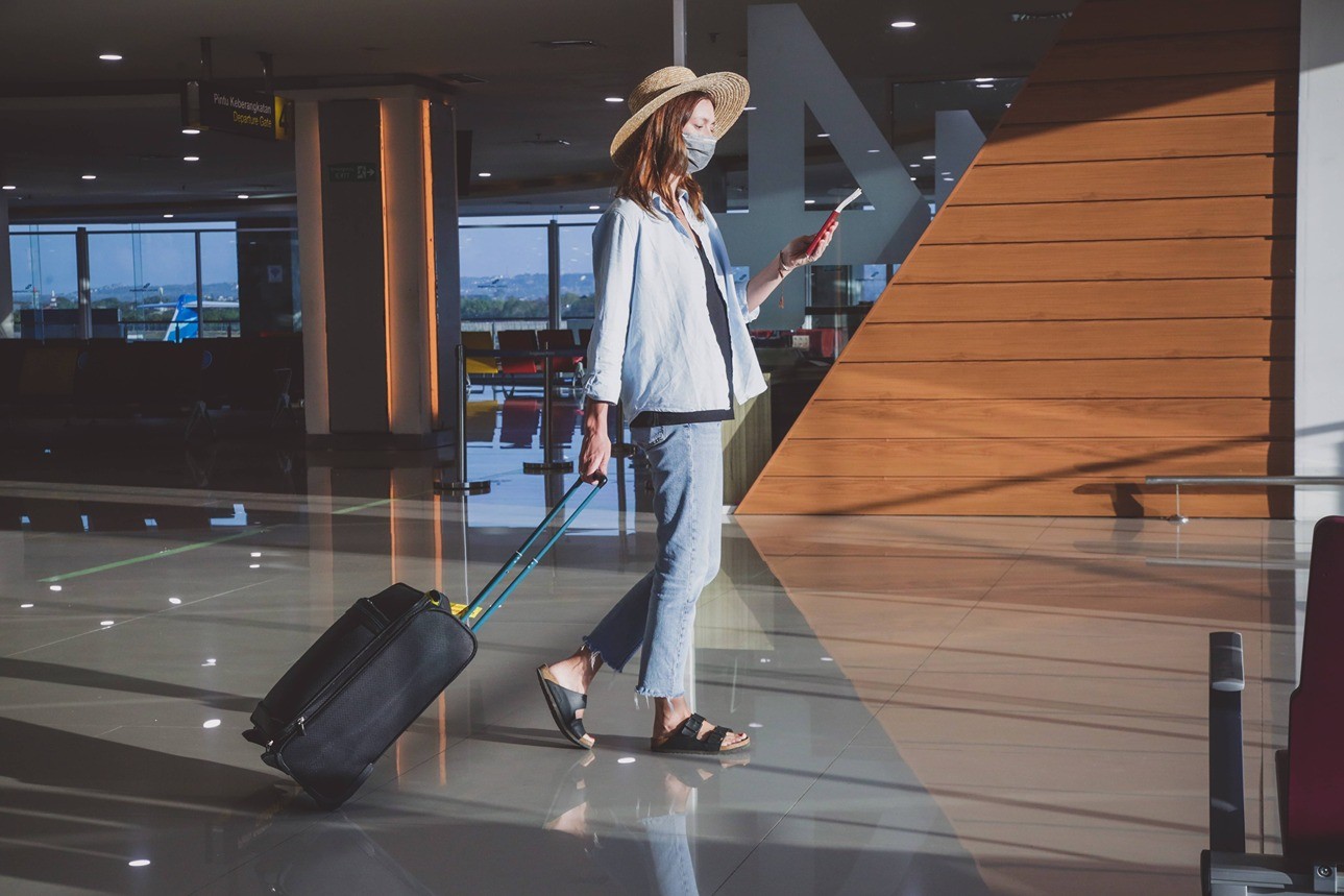 A woman with a suitcase at an airport.