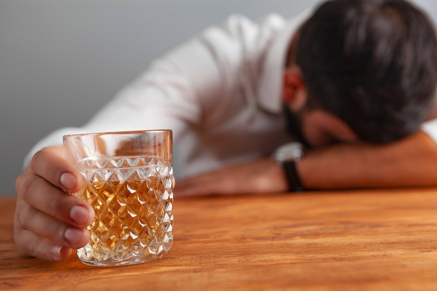 Men drinking a glass of alcohol.