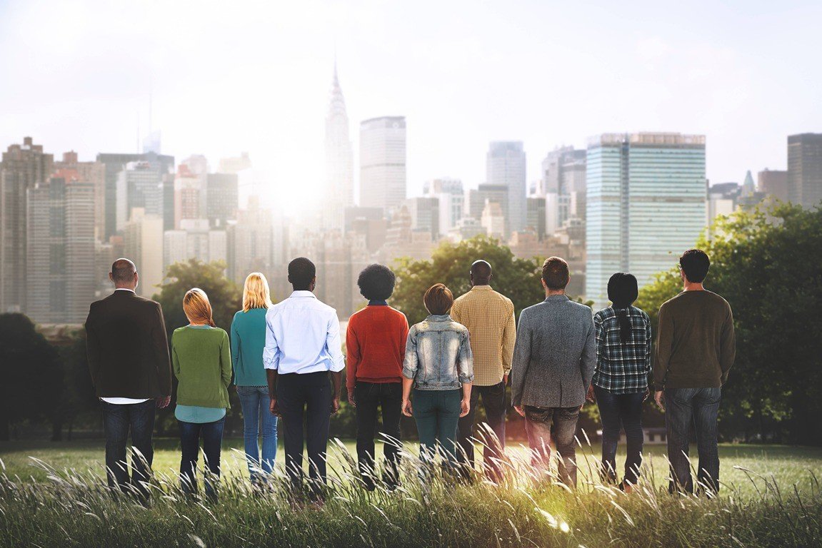 Group of people standing in the park looking at the sun