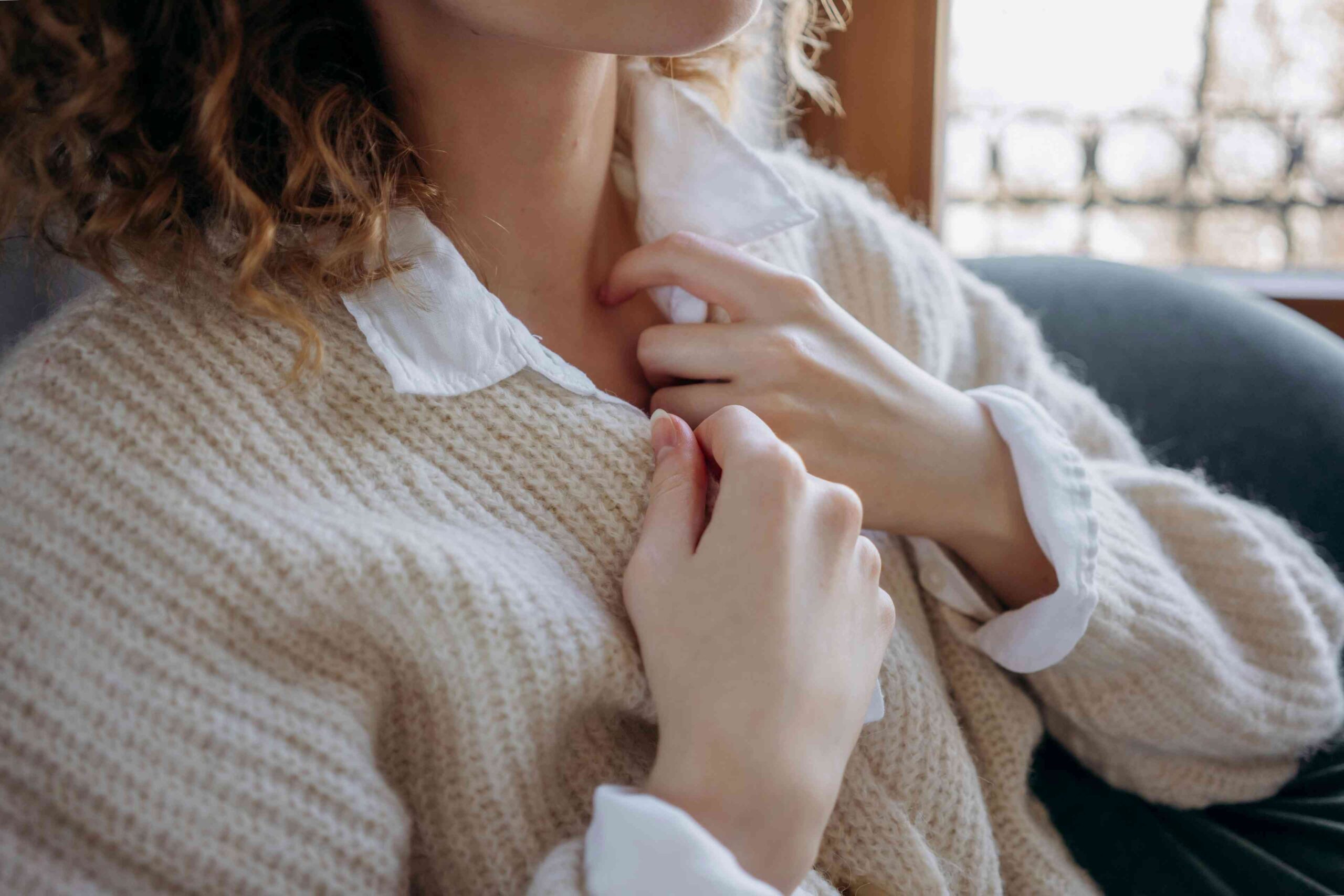 Hands holding chest due to heartburn caused by reflux disease.
