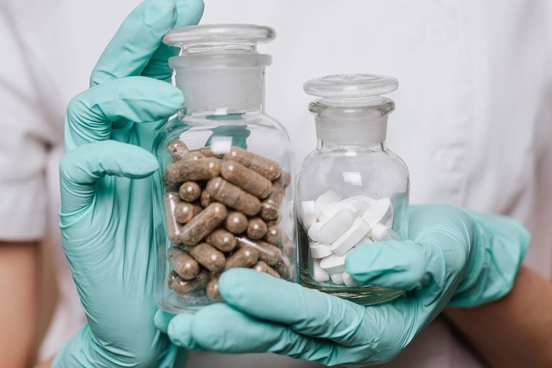 Doctor holding medicine bottles in hands.